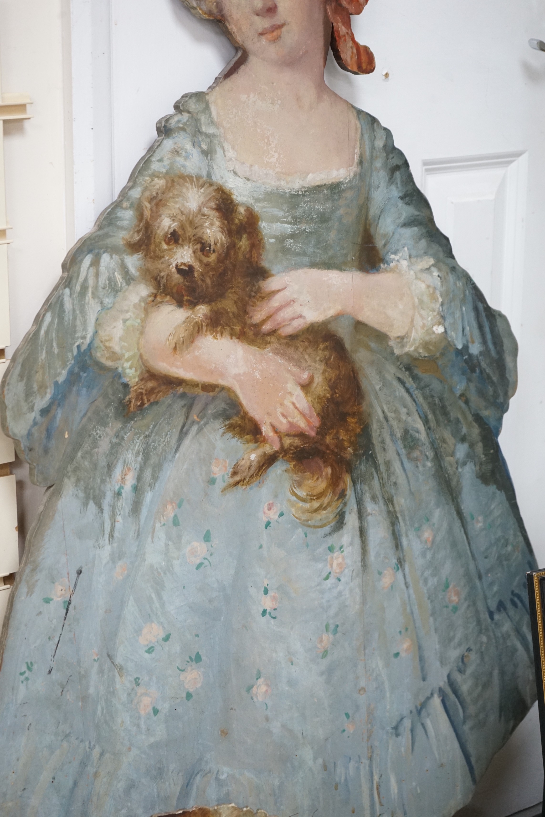 Two painted wood dummy boards, early 20th century, standing figure of a young girl holding a dog, in imitation of Pompeo Batoni (1708-1787), portrait of Countess Stanhope, 112cm tall, together with a smaller wood standin